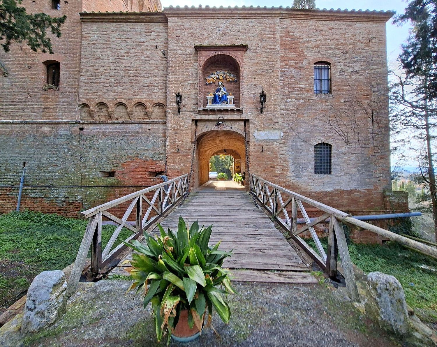 L'ingresso fortificato dell'abbazia di Monte Oliveto Maggiore, in mattoni, con il ponte in legno