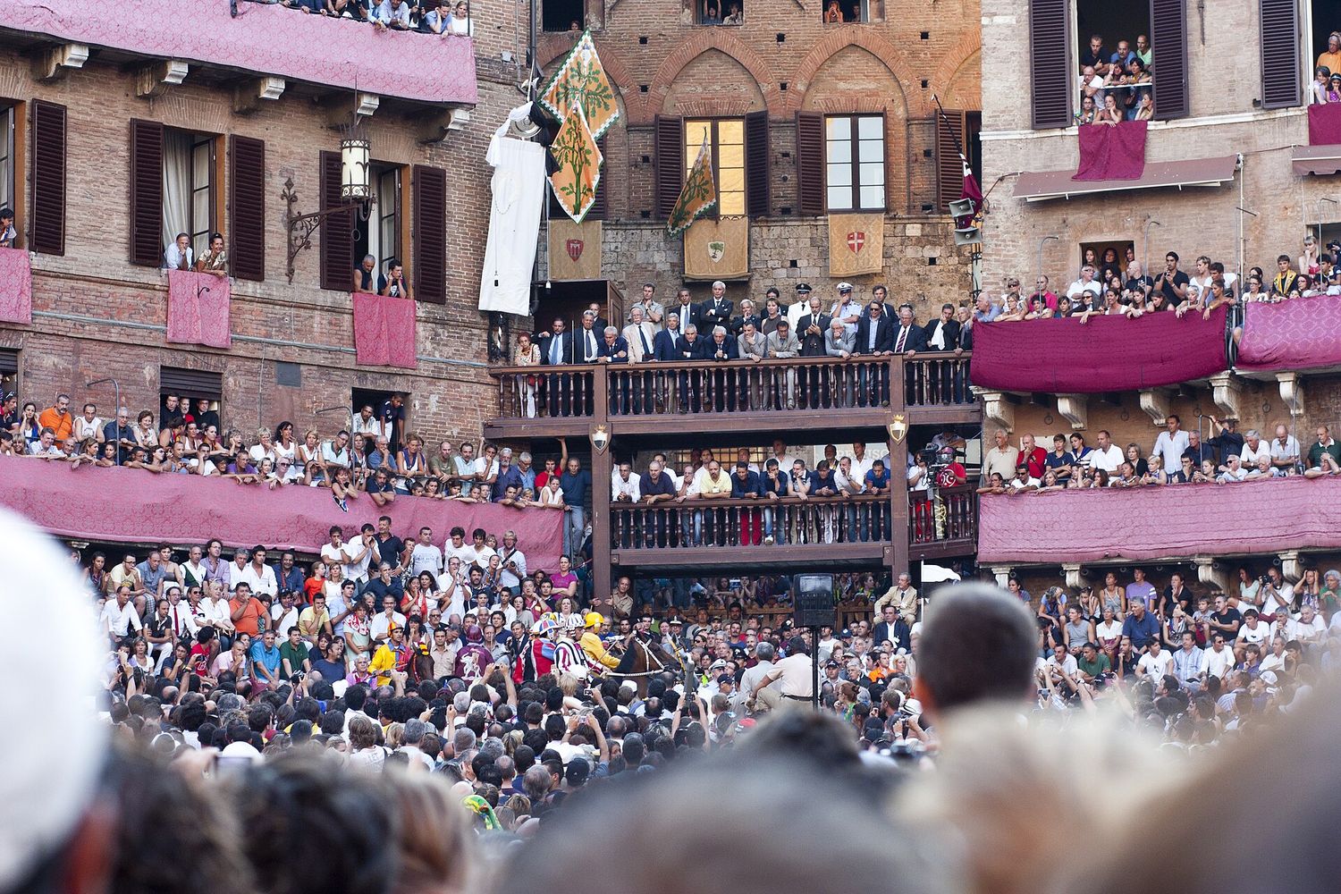 Il Palio di Siena: il palco dei giudici, i drappelloni e la folla in Piazza del Campo