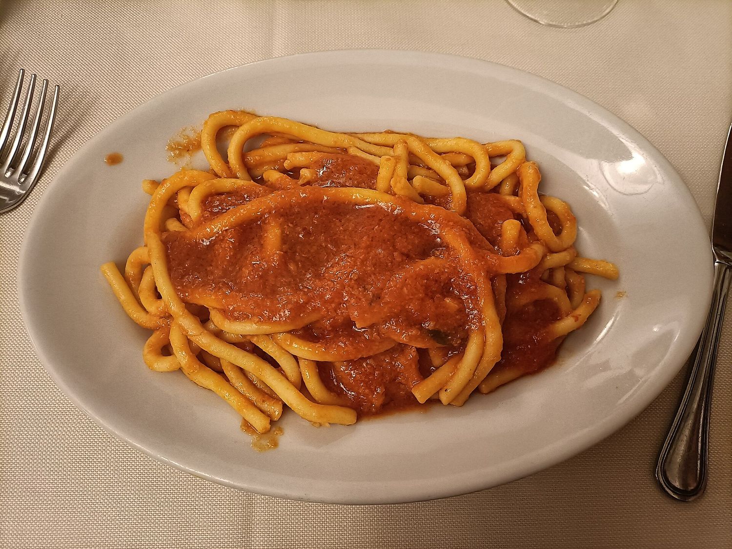 Un piatto di pici toscani conditi con sugo di pomodoro